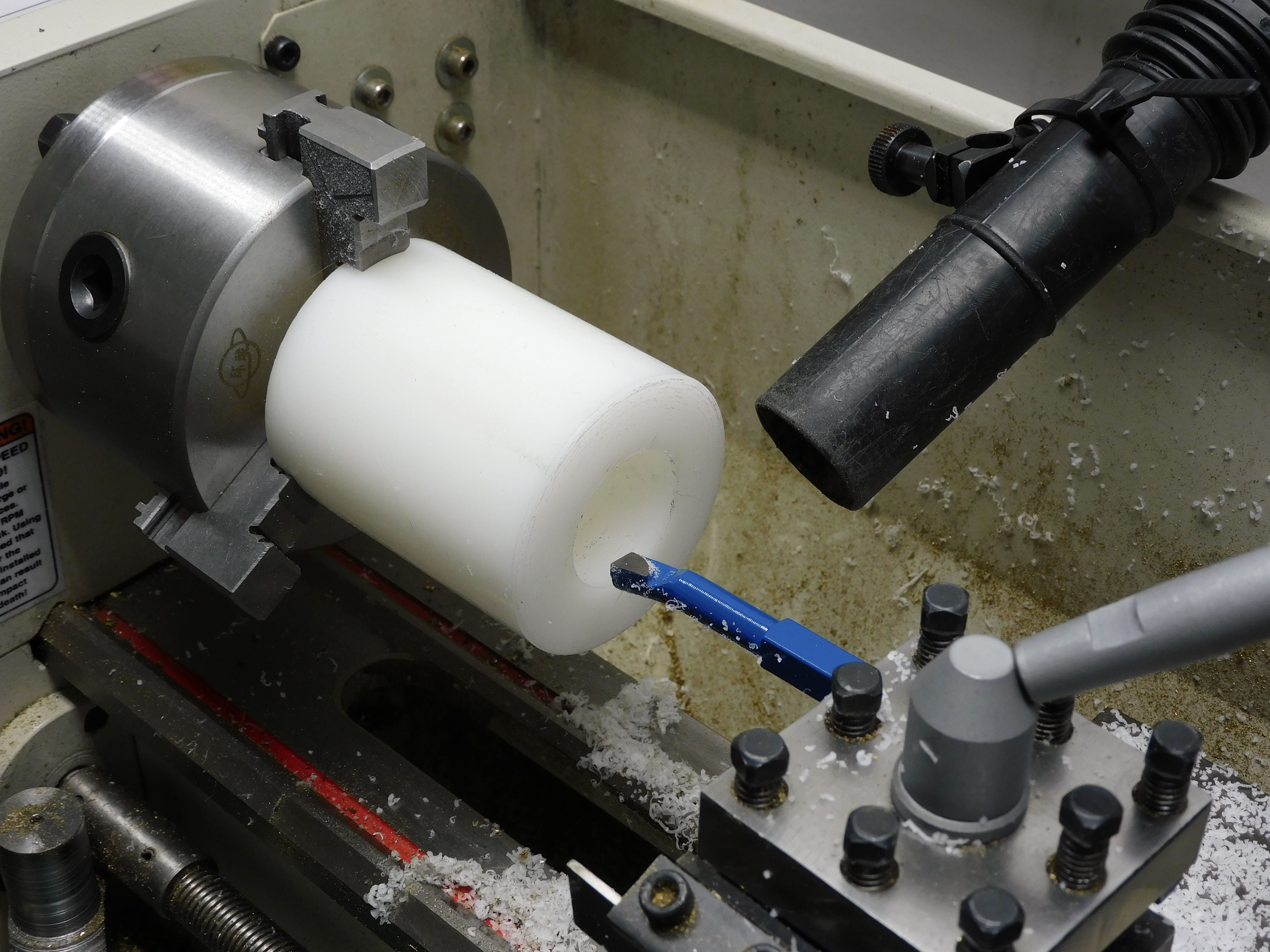 Acetal stock mounted on leathe for boring